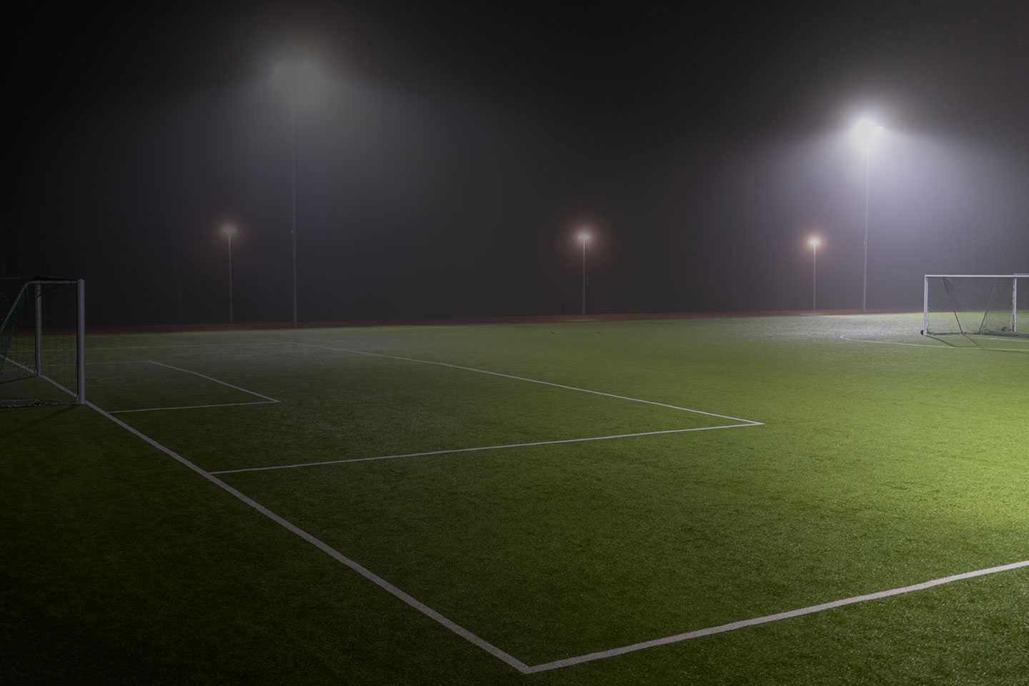 Nighttime view of a sports field illuminated by bright LED stadium lights in Texas. The powerful lights enhance visibility, casting a clear glow over the soccer field, ideal for late games and practices.